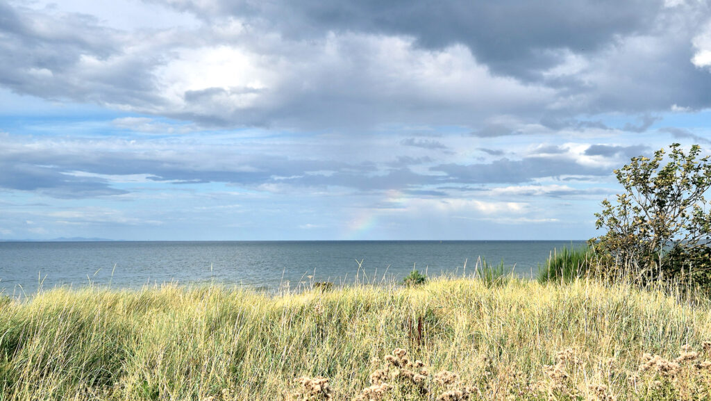 Ein Blick auf das Meer von Nairn mit Regenbogen am Himmel