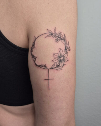 Venussymbol Tattoo Oberarm Tattoo eines Venussymbols mit Blumen und Stacheldraht auf einem Oberarm hinten.