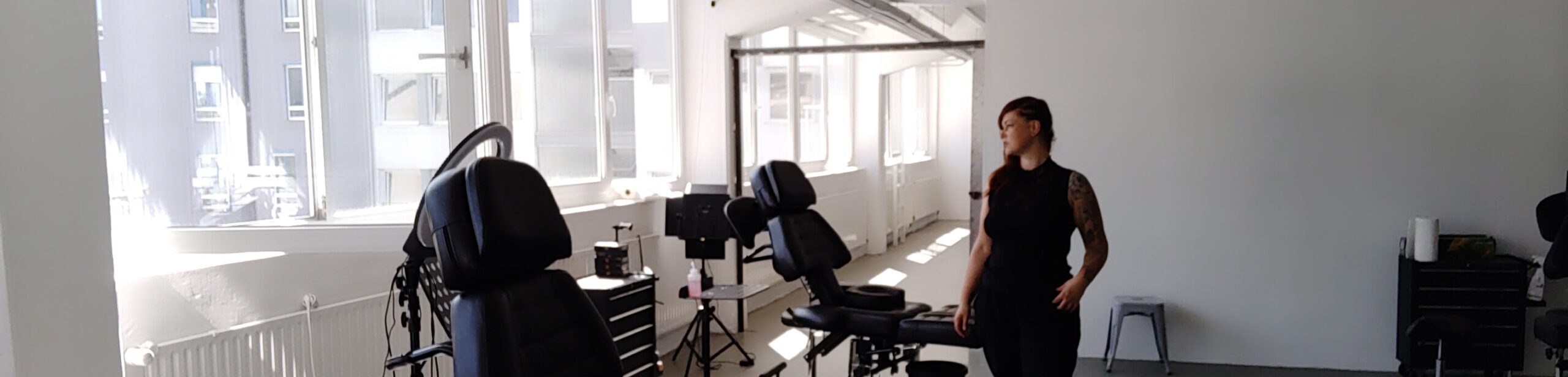 Grtoßräumiges Tattoostudio in Stuttgart mit mehreren Tattoostühlen und einer Person, einer Tattooartist